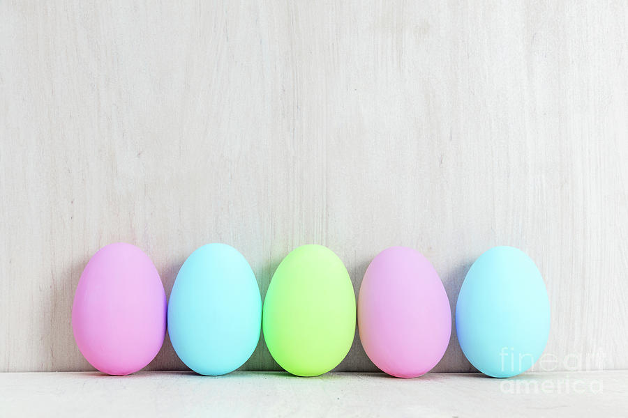 Pastel Easter eggs on wooden table. Photograph by Michal Bednarek