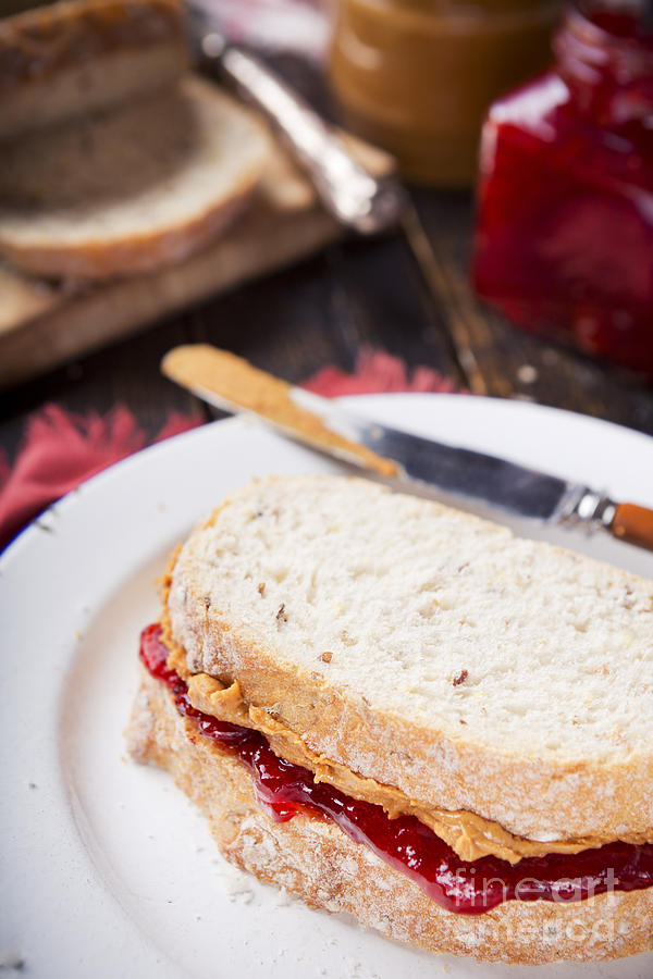 Bread Photograph - Peanut butter and jelly sandwich on a rustic table by Sara Winter