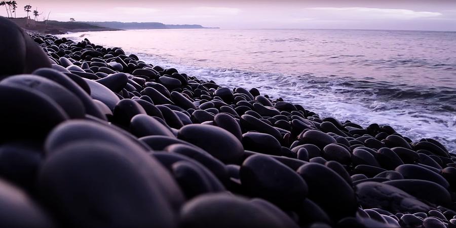 Pebbles on a background of beach 1 Photograph by Jean Francois Gil