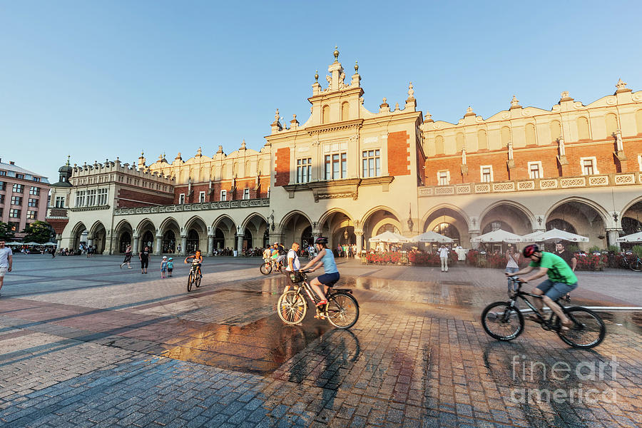 People cycling on the main market square of Cracow, Poland Photograph by Michal Bednarek