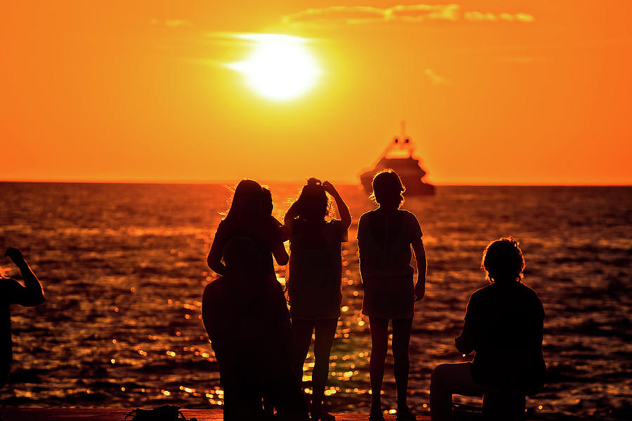 People silhouettes at golden sunset at sea and yacht on horizon Photograph by Brch Photography