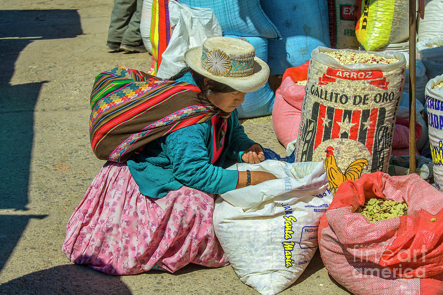 Peruvian woman looking at rice at market  Photograph by Patricia Hofmeester