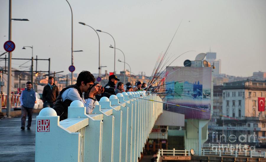 Photographer and people fishing from bridge crossing Bosphorus sea Istanbul Turkey Photograph by Imran Ahmed