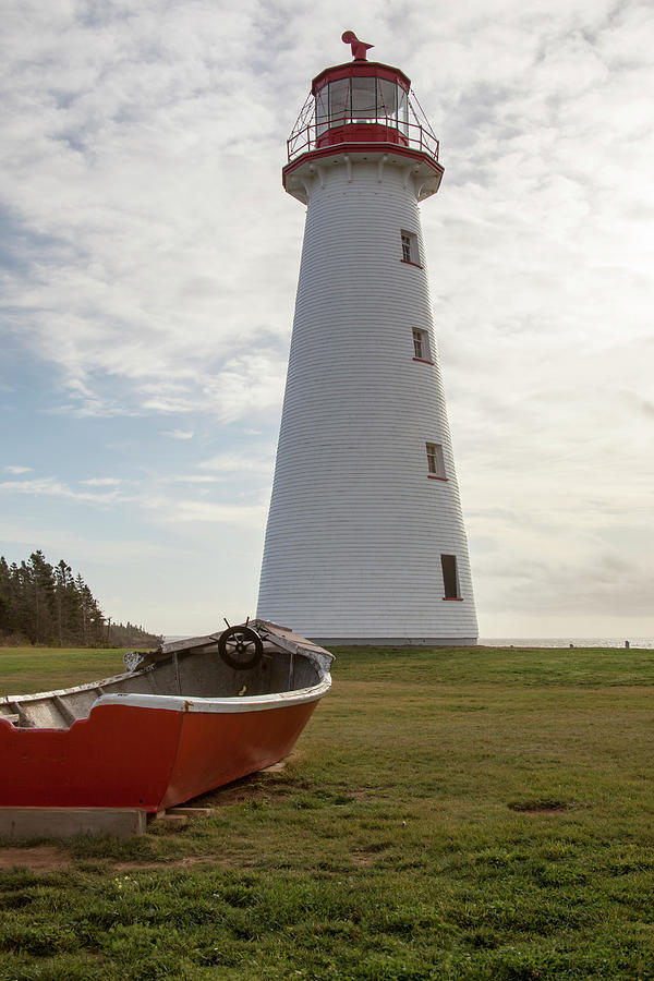 Point Prim Lighthouse, PEI and wooden boat Photograph by Karen Foley