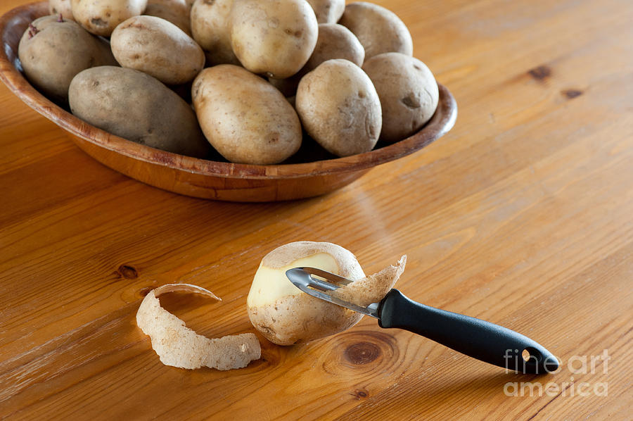 Potato Photograph - Potato peeler and peelings of tuber  by Arletta Cwalina
