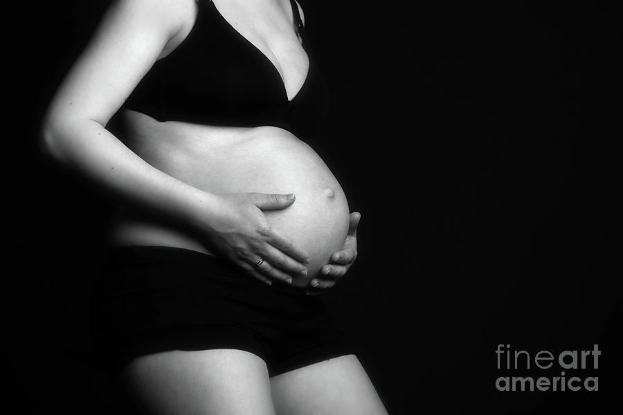Parenthood Movie Photograph - Pregnant woman sitting, touching her belly. by Michal Bednarek