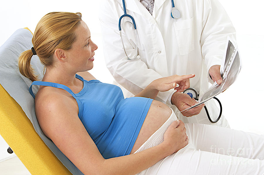 Pregnant Woman Views Ultrasound Scan Photograph by Jean-Paul Chassenet