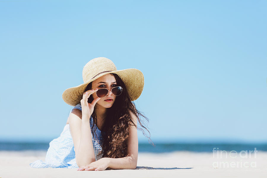 Pretty girl in straw hat laying on the sandy beach Photograph by Michal Bednarek