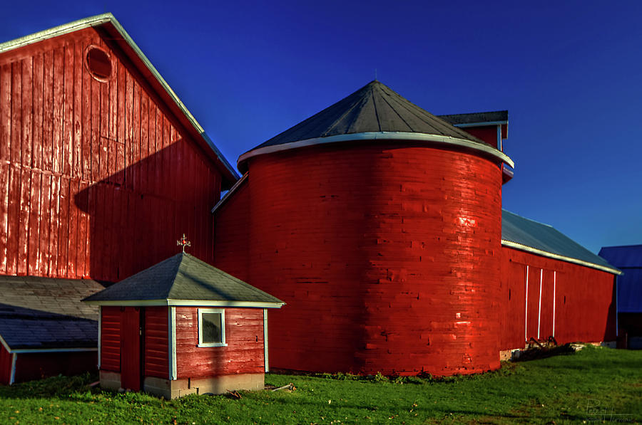 Primary Colors -  wooden barn and round wooden granary at farm south of Lake MIlls, WI  Photograph by Peter Herman