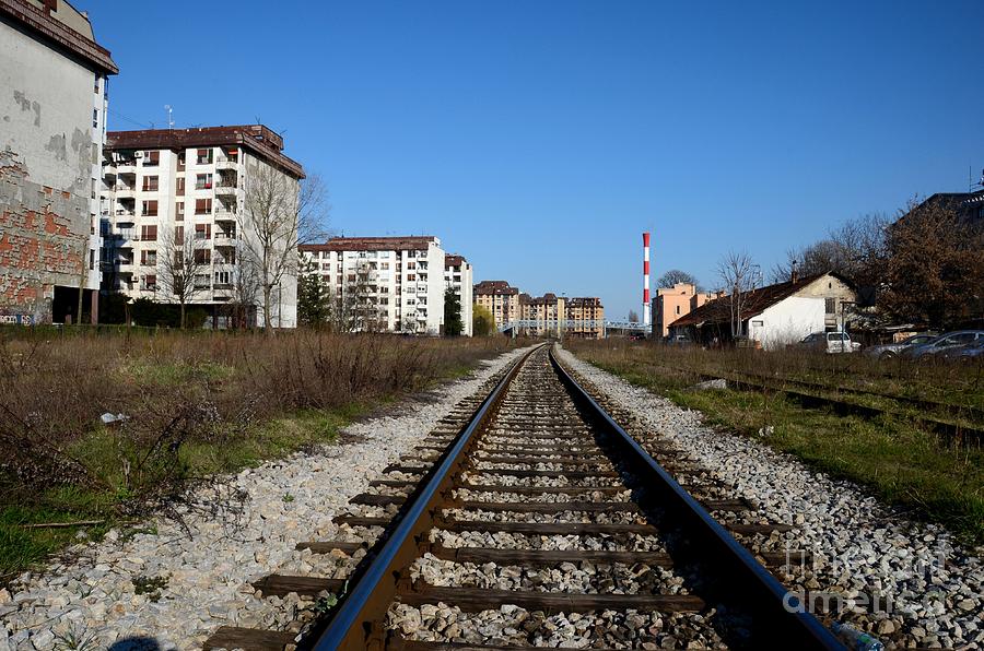 Railway tracks weathered apartment buildings and red industrial chimney Belgrade Serbia Photograph by Imran Ahmed