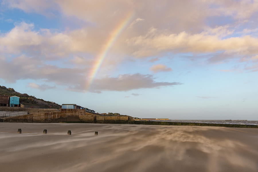 Rainbow over wind driven sand on Frinton beach Photograph by Gary Eason
