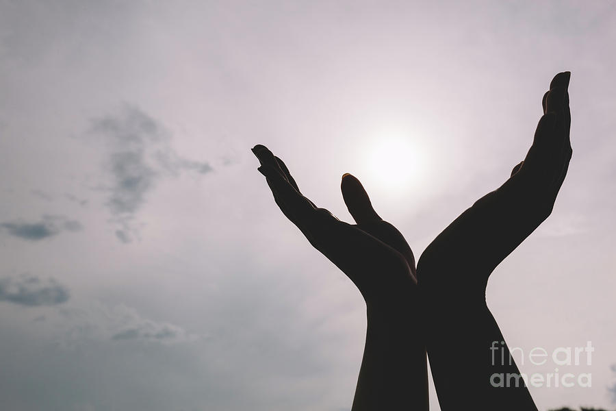 Raised hands reaching to the sky. Photograph by Michal Bednarek