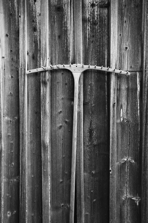 Rake leaning against log house wall - monochrome Photograph by Ulrich Kunst And Bettina Scheidulin