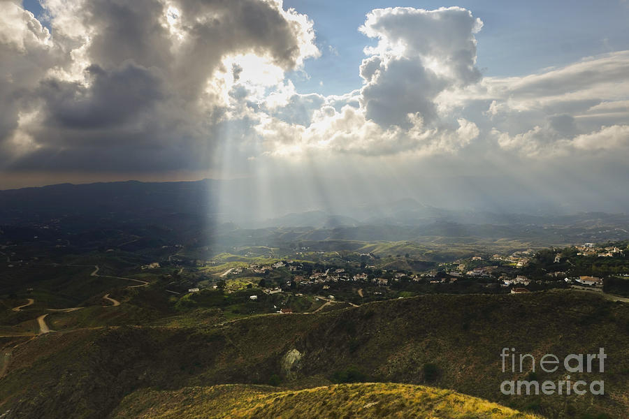 Rays of sunlight, lighten up spanish farmland in Andalusia, Spain. Photograph by Perry Van Munster
