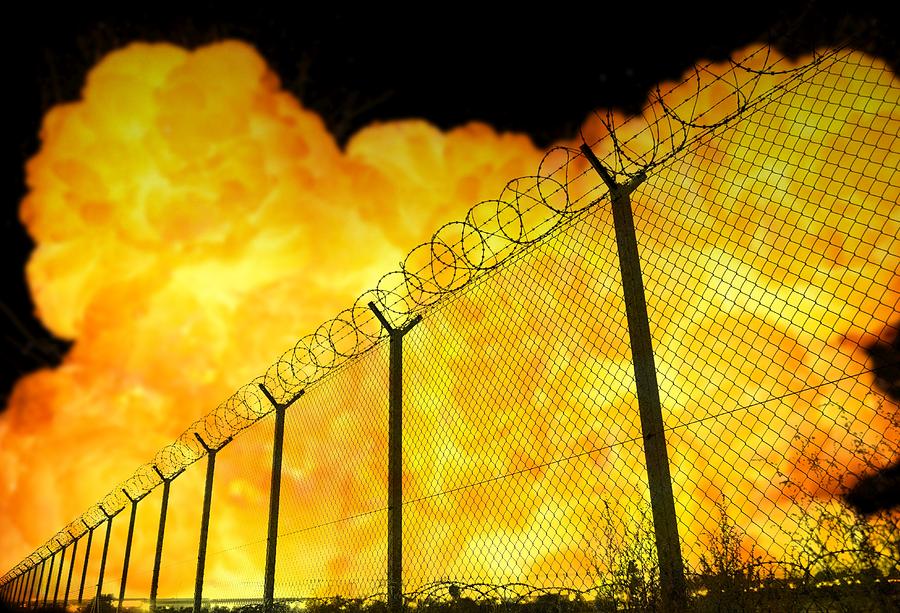 Airport Photograph - Realistic orange fire explosion behind restricted area barbed wire fence, blurred background by Lukasz Szczepanski