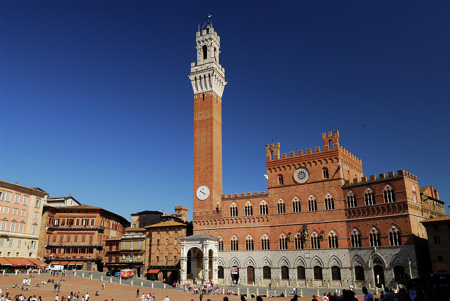 Red brick of the Palazzo Pubblico in Siena against a clear blue ...