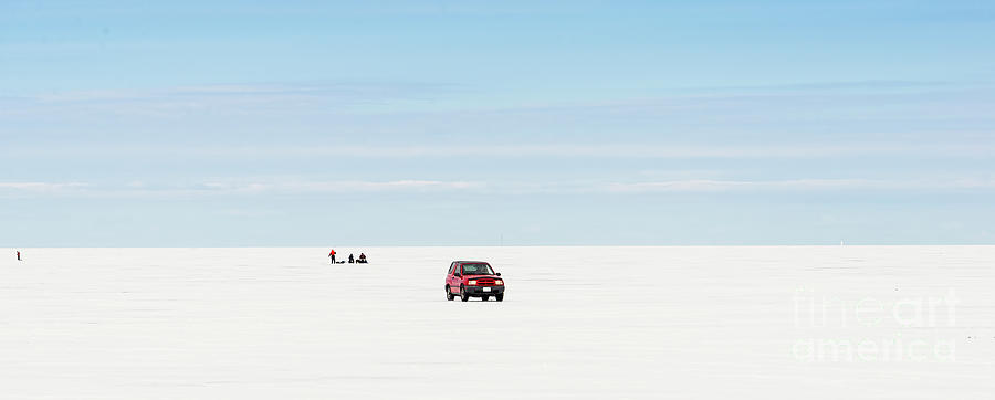 Red car driving on a frozen lake Simcoe Photograph by Les Palenik