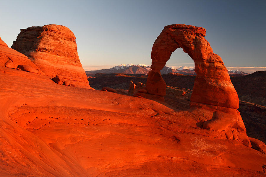 Red glow of Delicate Arch in Arches National park Photograph by Pierre Leclerc Photography