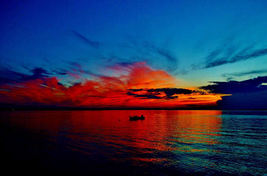 Red Horizon clouds with deep blue sky above reflecting off a fairly calm Indian River Bay Photograph by Billy Beck