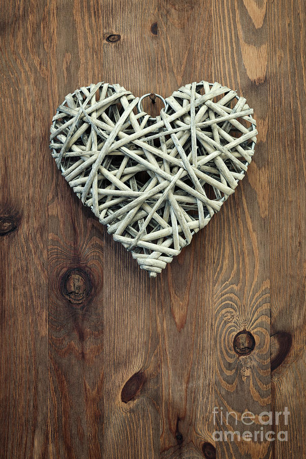 Reed Heart Hanging Against A Rustic Wooden Background. Photograph