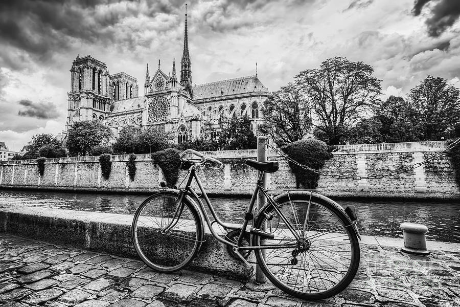 Paris Photograph - Retro bike next to Notre Dame Cathedral in Paris, France. Black and white by Michal Bednarek