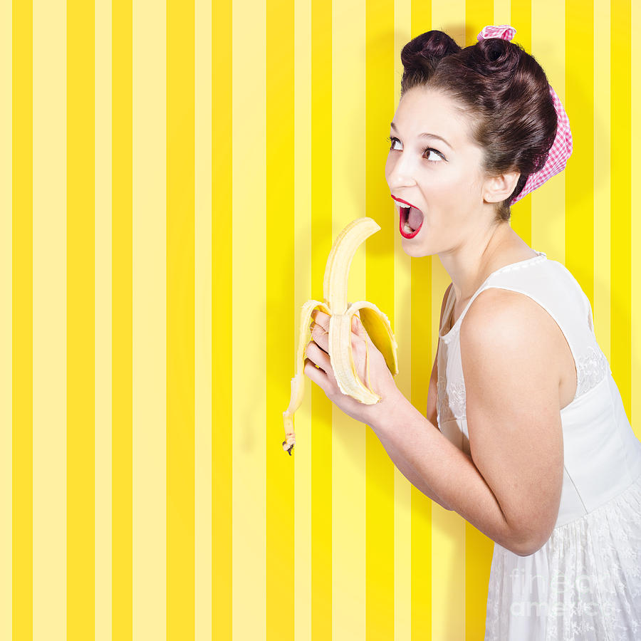 Retro Pinup Girl Eating Banana In 1950s Fashion Photograph