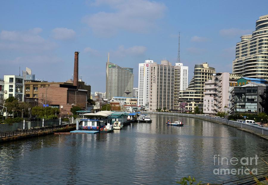 River canal with utility boat chimney and tall buildings Shanghai China Photograph by Imran Ahmed