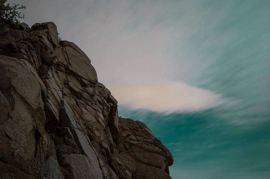 Rock Outcropping At Night, Set In Front of A Dark Teal Sky With Lots of Cloud Motion Photograph by Brian Ball