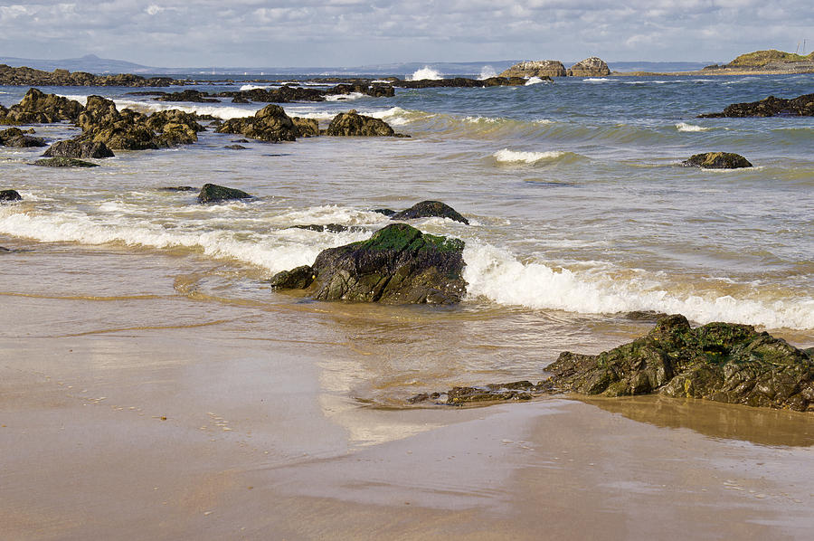 Rocks, waves, sand and sky reflection. Photograph by Elena Perelman