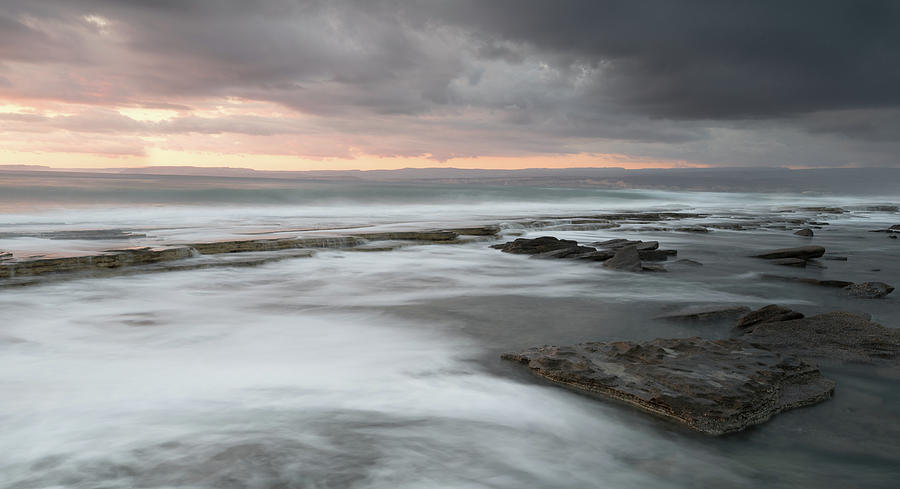 Rocky seashore seascape with wavy ocean during sunset  Photograph by Michalakis Ppalis