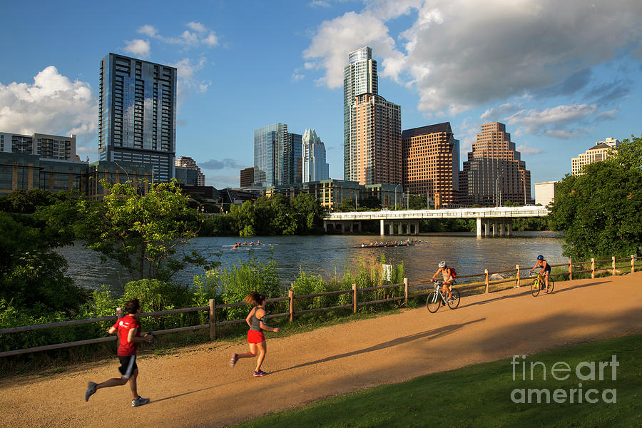 Austin Skyline Photograph - Runners and bikers exercise on the hike and bike trail while rowing teams train on Lady Bird Lake by Dan Herron