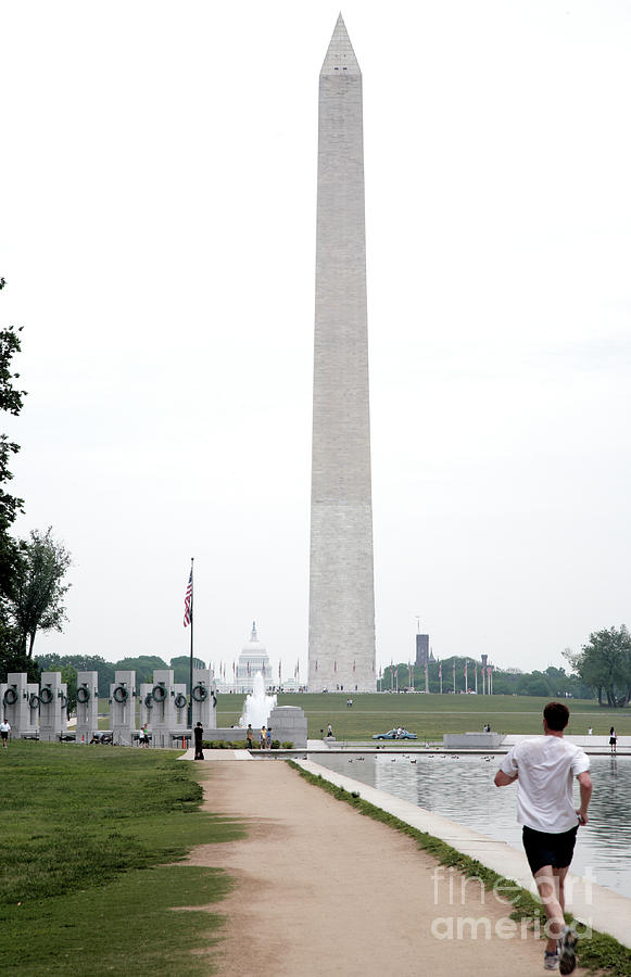 Running past the Reflecting Pool towards the Washington Monument Photograph by William Kuta