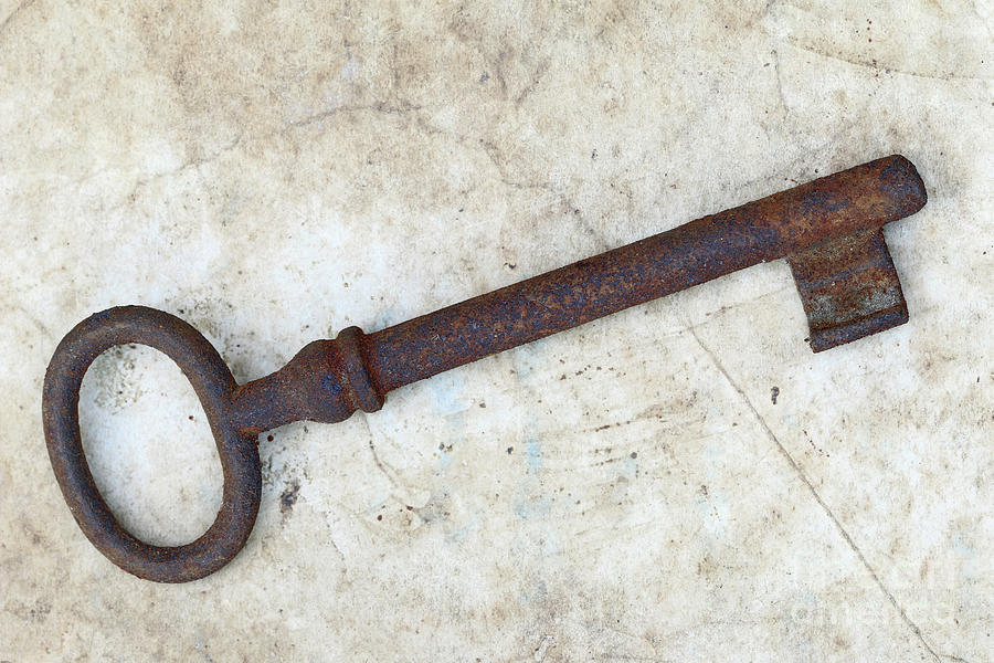 Rusty key on old parchment Photograph by Michal Boubin