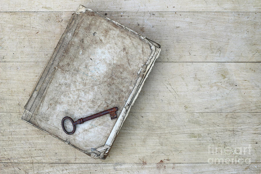 Rusty key on the old tattered book Photograph by Michal Boubin
