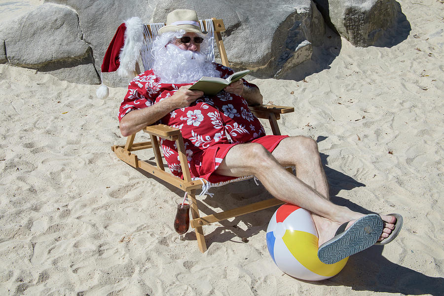 Santa Claus reading novel on sunny beach Photograph by Karen Foley