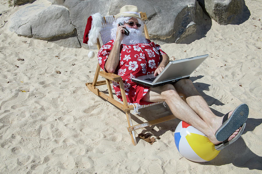 Santa Claus talking on the phone on beach chair with laptop comp Photograph by Karen Foley