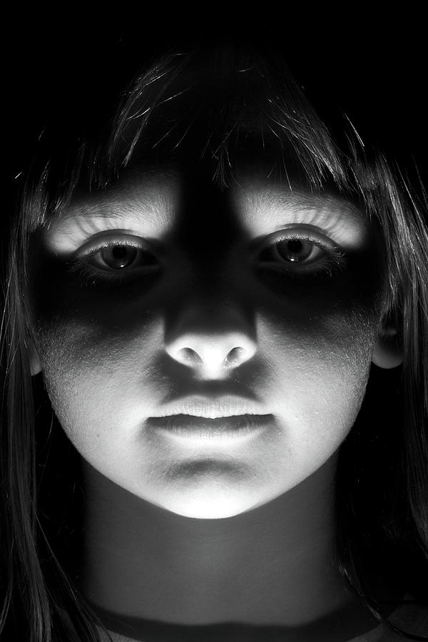 Scary kid with light shining up on her face Photograph by Kyle Lee