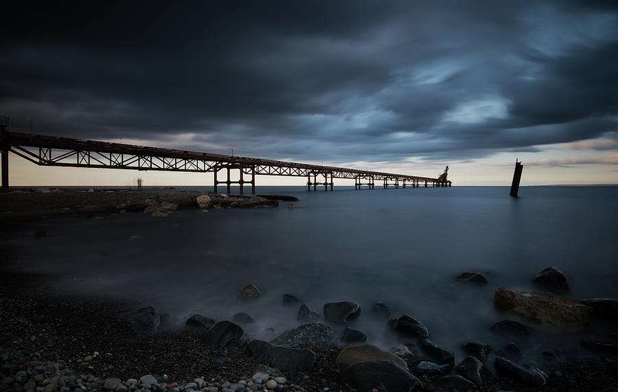 Seascape With Jetty During A Dramatic Cloudy Sunset Photograph