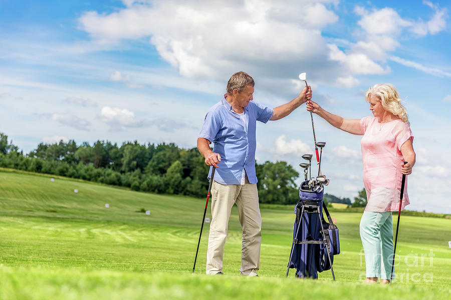 Senior couple choosing equipment for a golf game. Photograph by Michal Bednarek