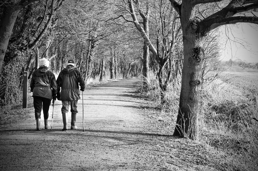 Nature Photograph - Senior Couple Walking Through The Woods by Fizzy Image