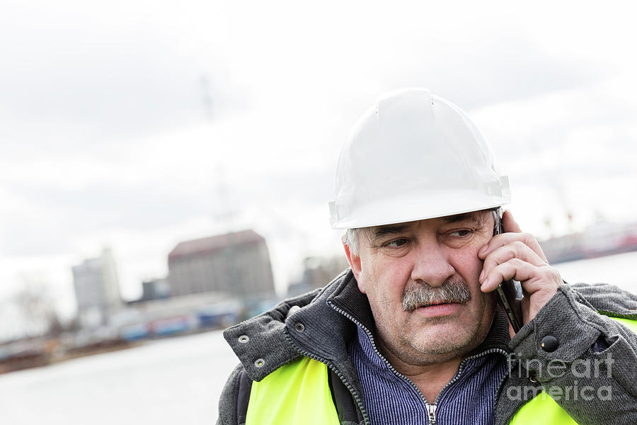 Senior engineer builder on the phone at construction site. Photograph by Michal Bednarek