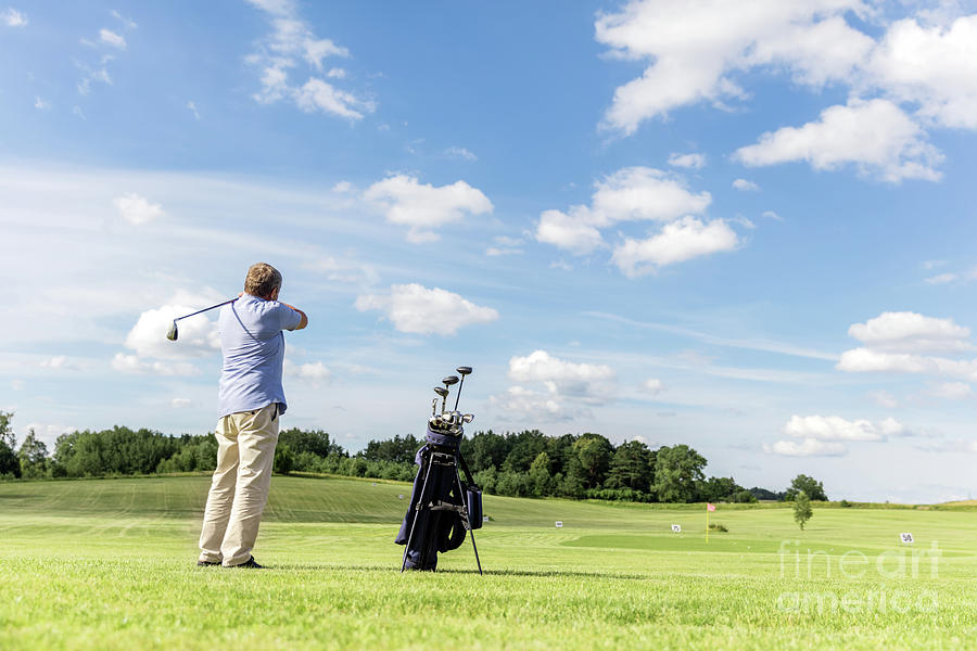 Senior fit man hitting a golf ball. Photograph by Michal Bednarek