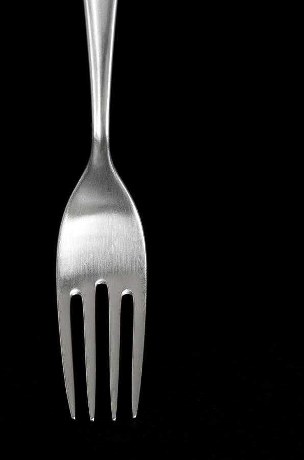 Black And White Photograph - Shiny silver fork on black background by GoodMood Art