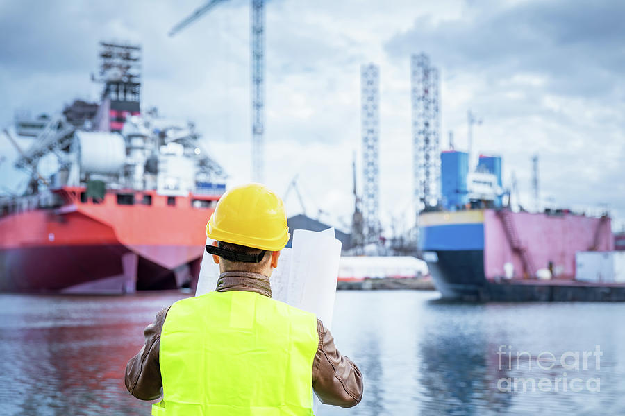 Shipbuilding engineer checking documents at the dockside in a port. Photograph by Michal Bednarek
