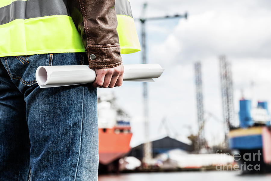 Shipbuilding engineer holding construction documents. Photograph by Michal Bednarek