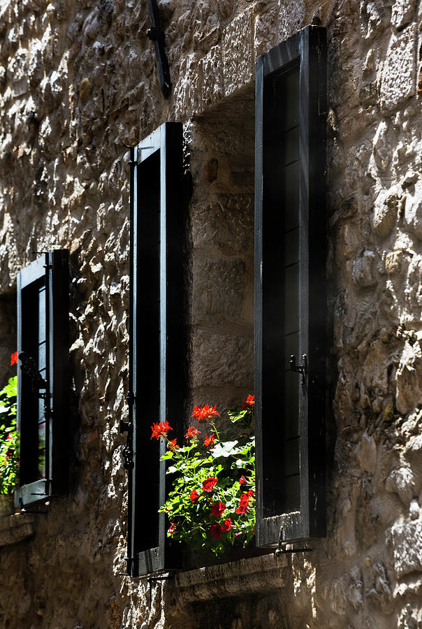 Shuttered window with red Geranium, Saint Paul de Vence, France. Photograph by Maggie Mccall
