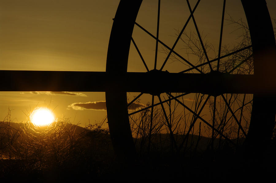 Sunset Photograph - Silhouette of Retired Irrigation Wheel by Larry Kjorvestad