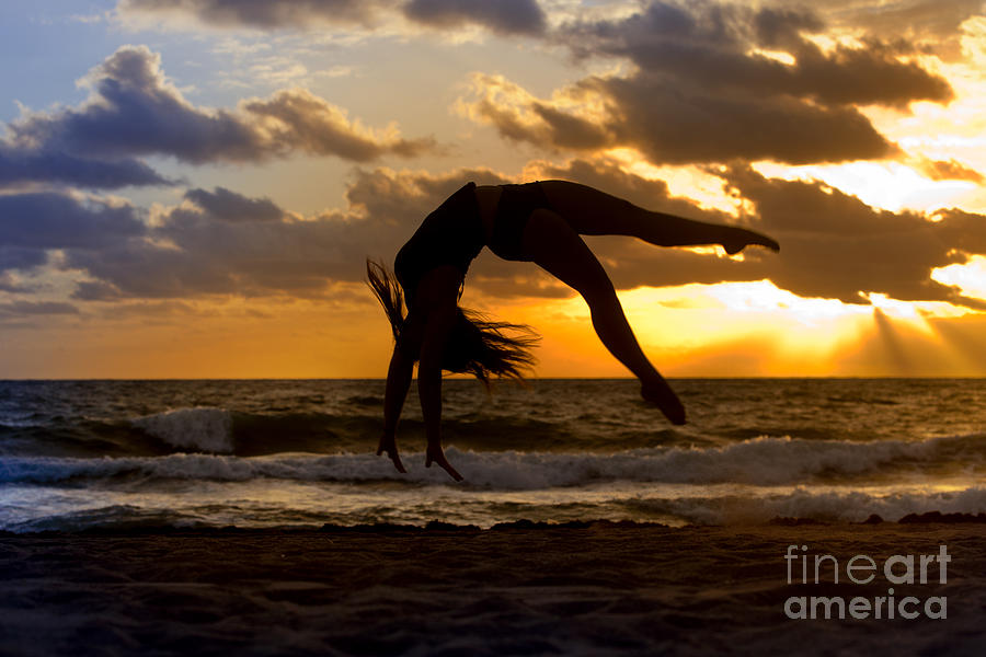 Silhouette of woman doing a back flip on a beach Photograph by Anthony Totah