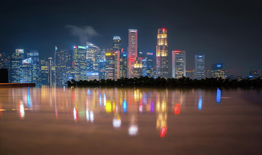 Singapore cityscape on night with reflection on the floor from roof top Photograph by Anek Suwannaphoom