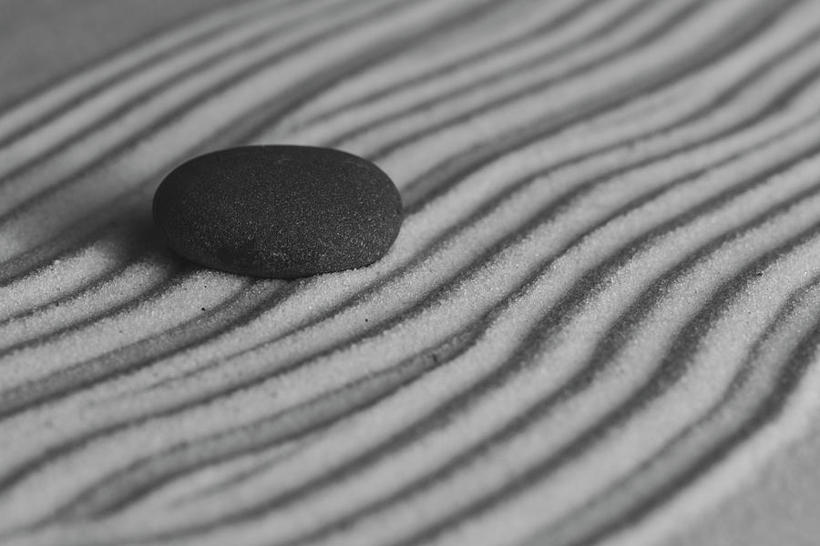Single Meditation Stone on Flowing Waves of Sand Black and White Photograph by Andrew Pacheco